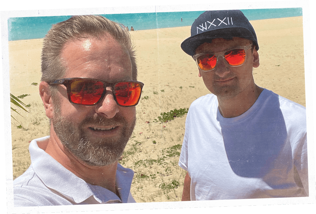 Giles Vincent and Craig Sparkes in sunglasses on the beach